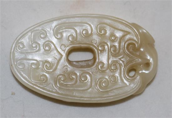 A Chinese archaistic white and pale russet jade oval disc, 4.9cm